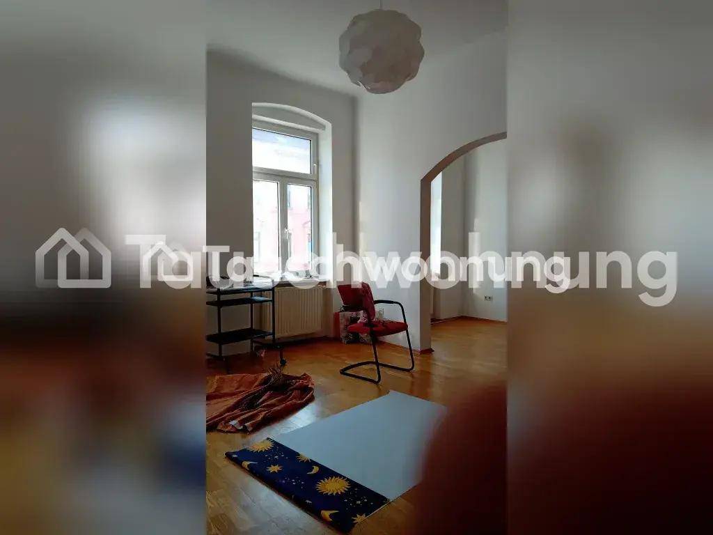 Heller Wohnraum mit Holzboden, großem Fenster und einem dekorativen Bogen.