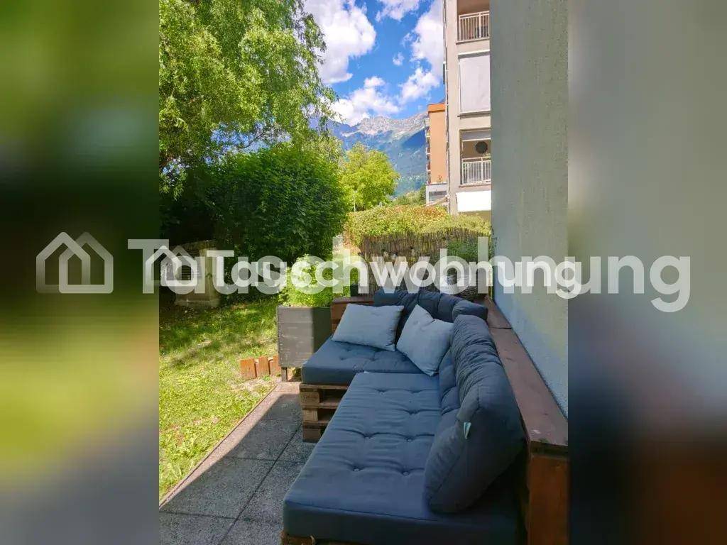Terrasse mit bequemen Palettenmöbeln und einem schönen Blick auf die umliegenden Berge.