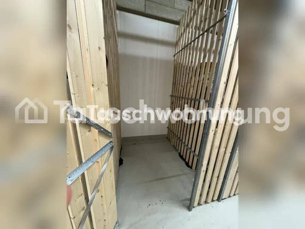 Geräumiger Abstellraum mit Holzlattenwänden und Betonboden für zusätzlichen Stauraum.