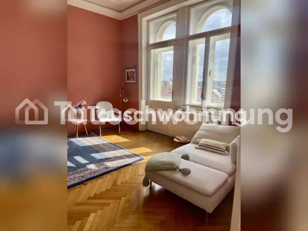 Gemütliches Wohnzimmer mit Chaiselongue, Fischgrätparkett und großen, lichtdurchfluteten Bogenfenstern.