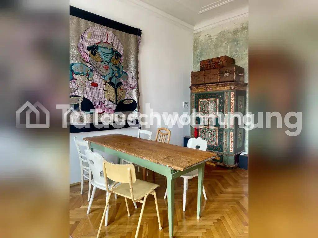 Esszimmer mit rustikalem Holztisch, verschiedenen Stühlen und einem großen Wandteppich als Dekoration.