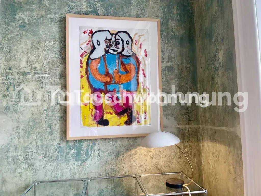 Nahaufnahme eines farbenfrohen Kunstwerks an einer strukturierten grünen Wand mit einer Lampe.