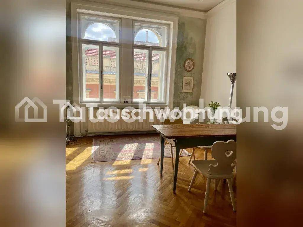 Essbereich mit Holztisch, Stühlen, Fischgrätparkett und großen Fenstern für viel Tageslicht.