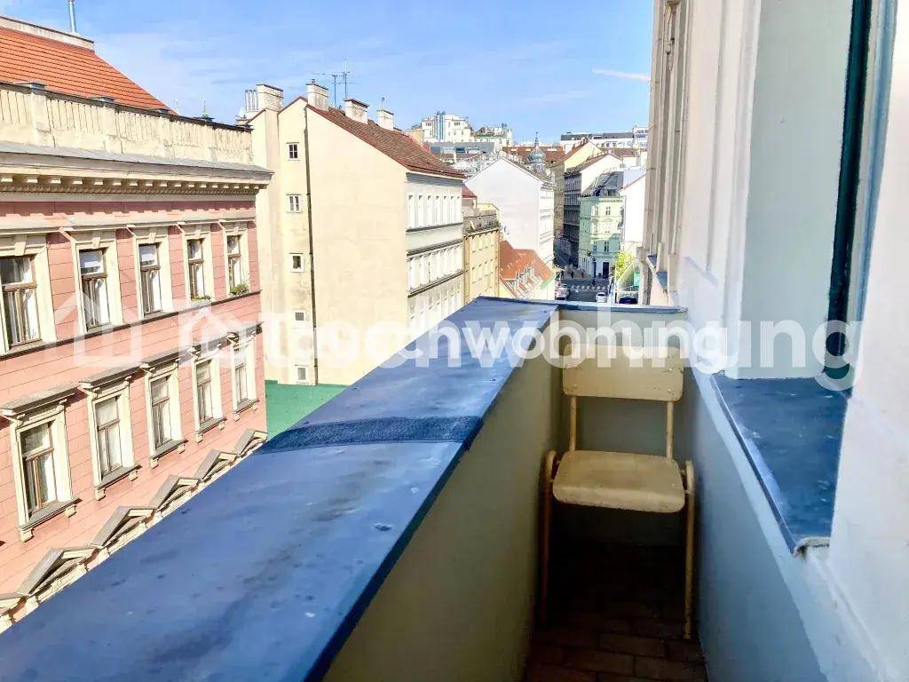 Kleiner Balkon mit einem Stuhl und Blick auf die umliegenden historischen Stadtgebäude.