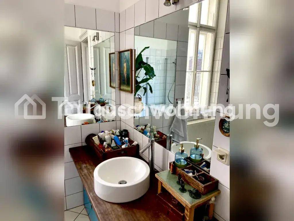 Badezimmer mit weißen Fliesen, einem großen Spiegel über dem Waschbecken und einem Fenster.