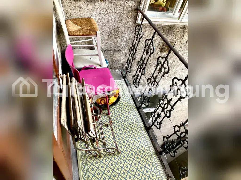 Treppenhaus mit kunstvollem Metallgeländer und einem gemusterten Teppich auf der Treppe.