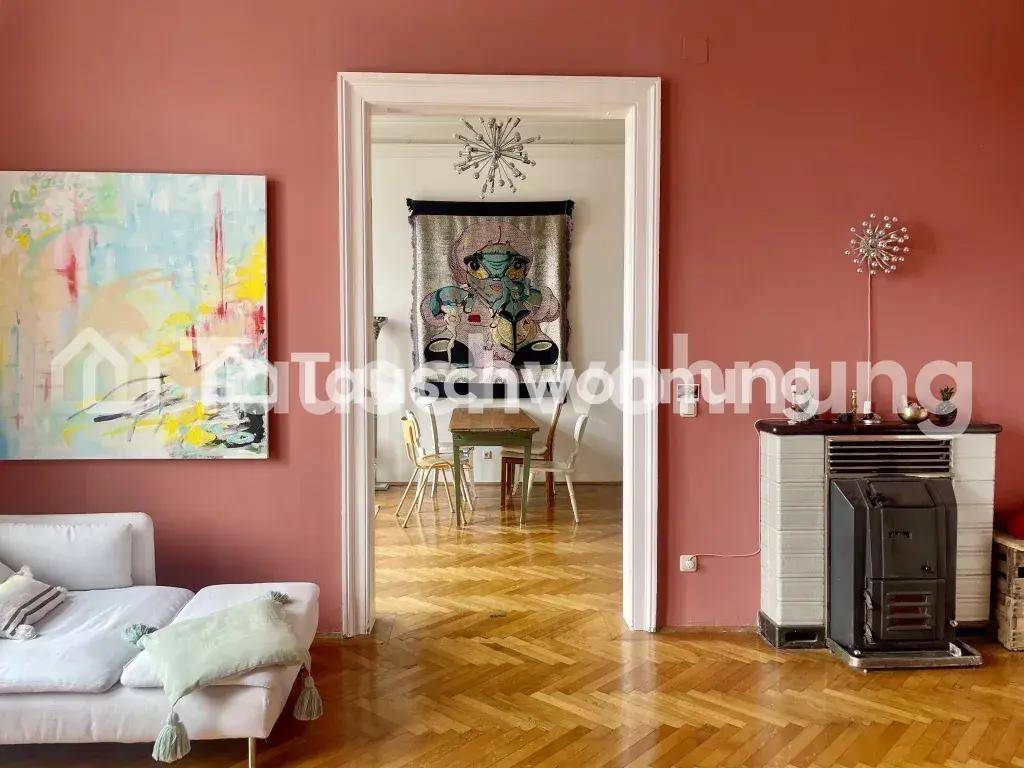 Offener Wohnbereich mit rosa Wänden, Fischgrätparkett und Blick in den angrenzenden Essbereich.