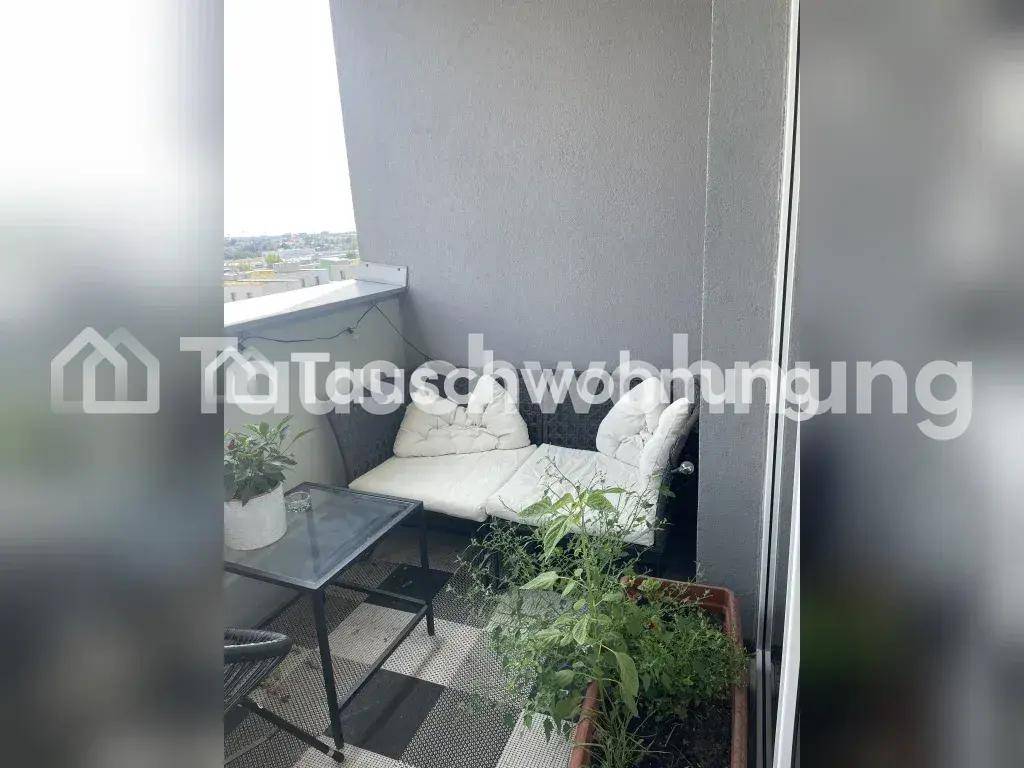 Kleiner Balkon mit bequemen Sitzgelegenheiten und Pflanzen, bietet einen Blick ins Grüne.