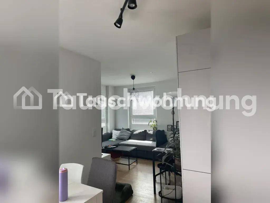 Helles Wohnzimmer mit modernem Sofa, dunklem Couchtisch und Laminatboden.