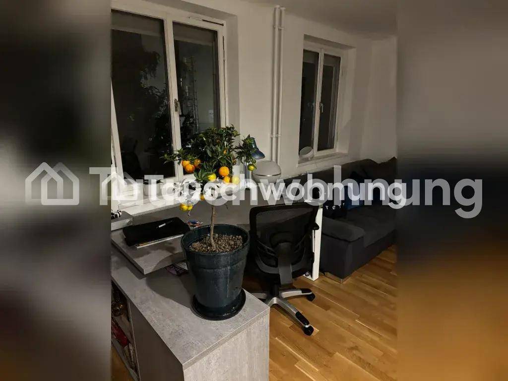 Wohnbereich mit Schreibtisch, Sofa und Fenstern, ausgestattet mit Holzfußboden.