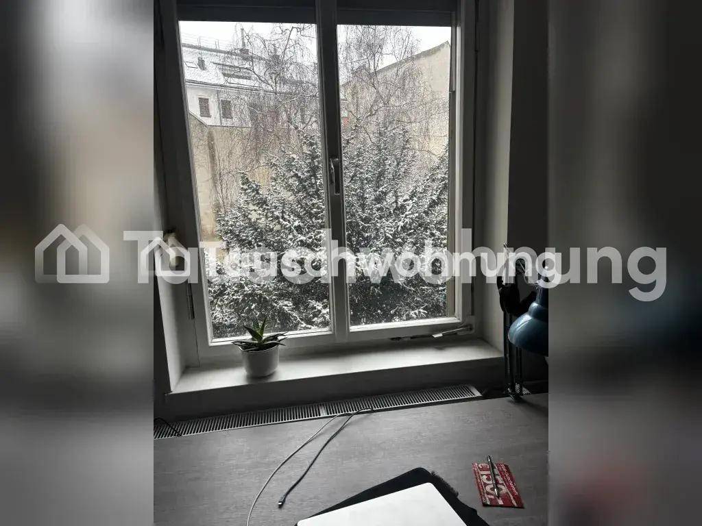 Blick aus dem Fenster auf kahle Bäume und Gebäude im Hintergrund.