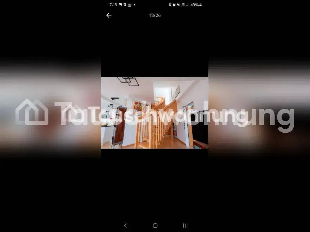 Heller Flur mit einer Holztreppe, die in die obere Etage führt und offene Gestaltung.