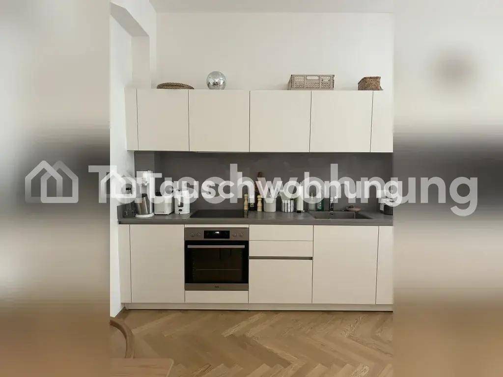 Moderne Einbauküche mit weißen Schränken, integriertem Backofen und Induktionskochfeld.