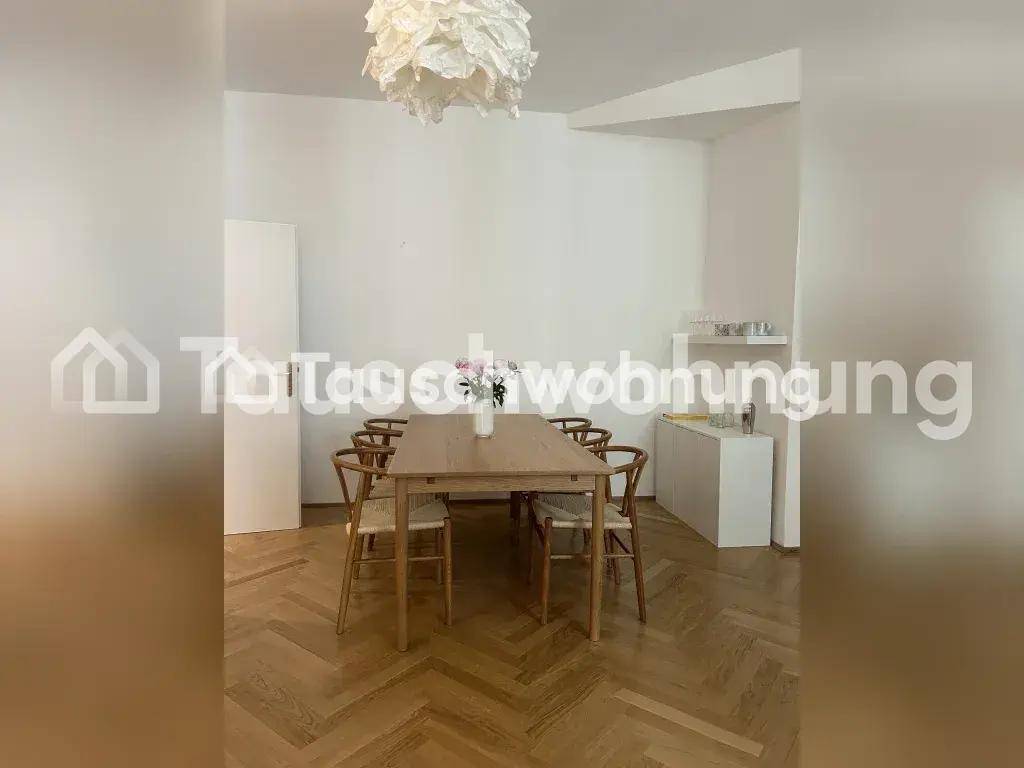 Geräumiger Essbereich mit Holztisch und Stühlen auf elegantem Fischgrätparkettboden.