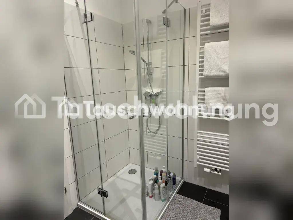 Modernes Badezimmer mit Duschkabine, weißen Fliesen und beheiztem Handtuchhalter.