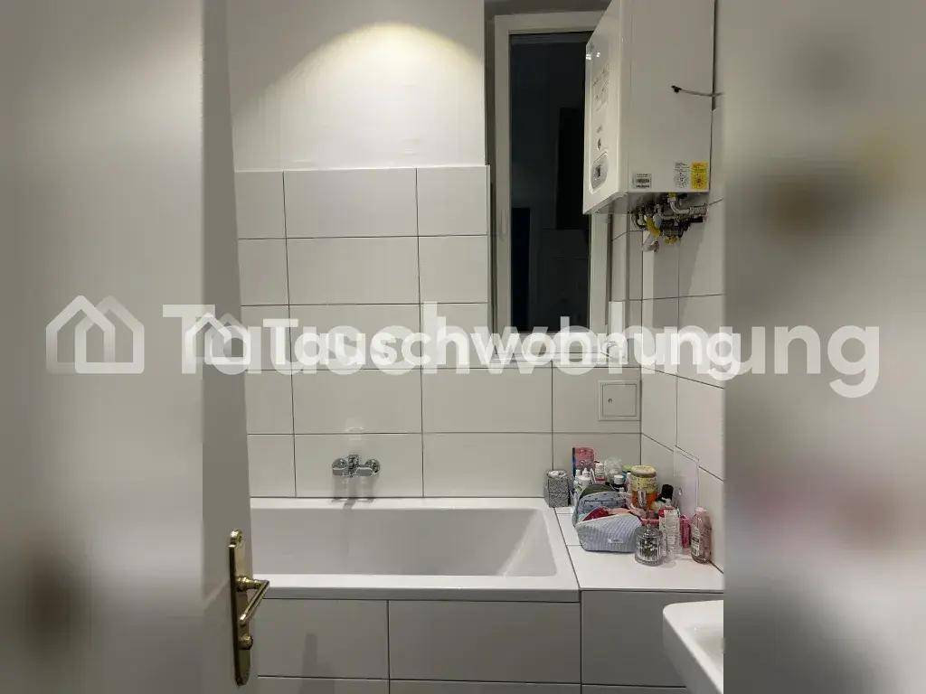 Badezimmer mit Badewanne, weißen Fliesen und einem Warmwasserbereiter an der Wand.
