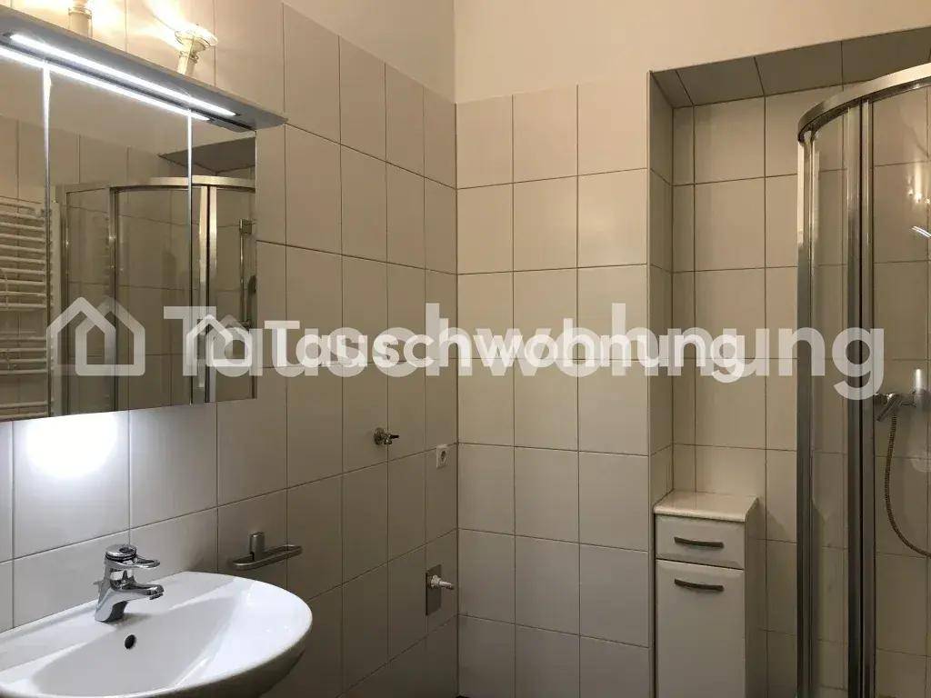 Modernes, gefliestes Badezimmer mit Duschkabine, Waschbecken und Spiegelschrank.