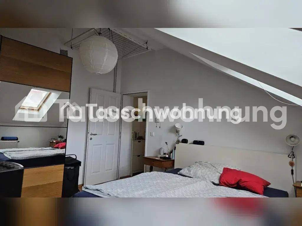 Gemütliches Dachgeschoss-Schlafzimmer mit Bett, Kleiderschrank und Dachschräge.