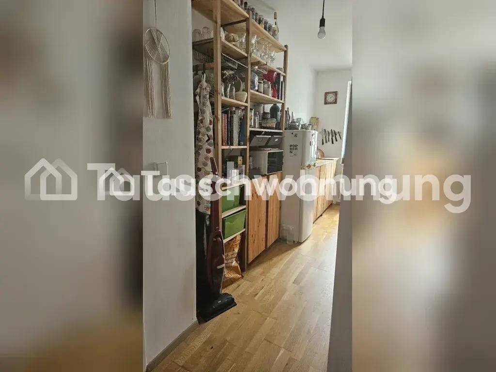 Schmale Küche mit Holzschränken, offenem Regal und Holzboden, funktional eingerichtet.