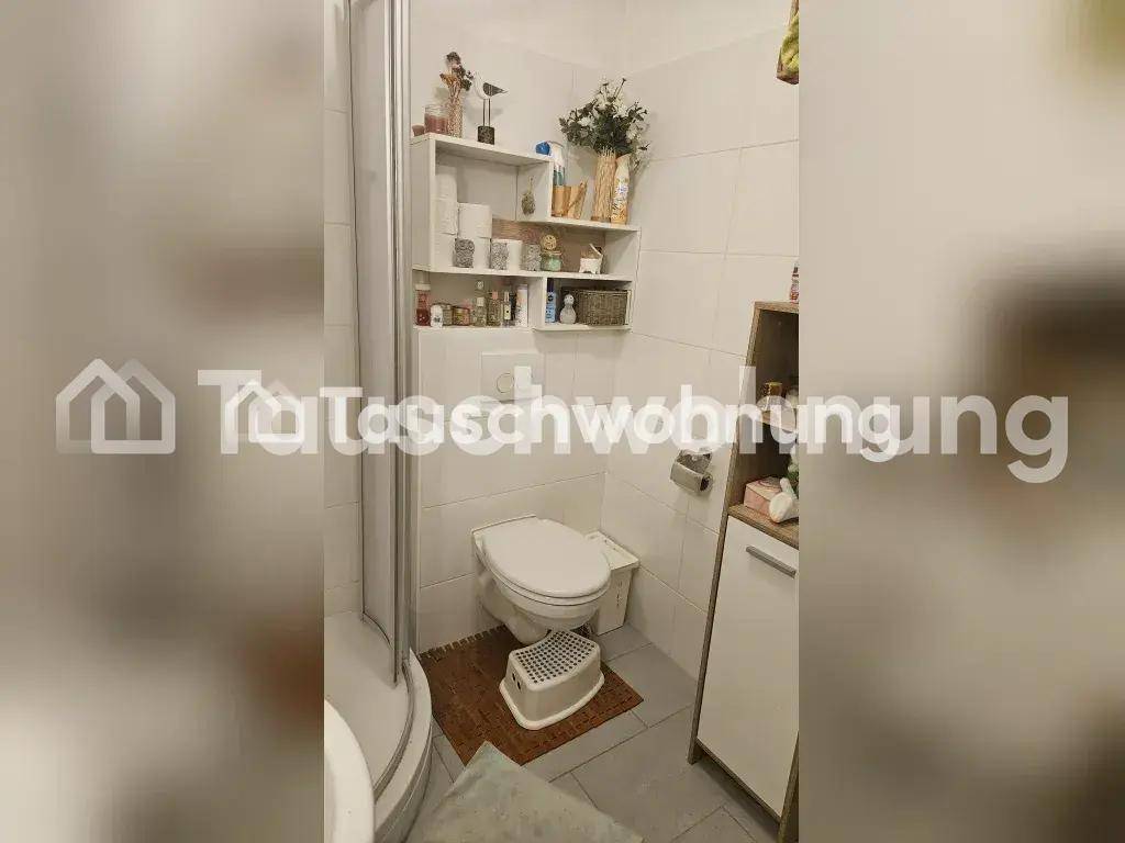 Modernes Badezimmer mit Dusche, WC und weißen Fliesen, sauber und funktional.