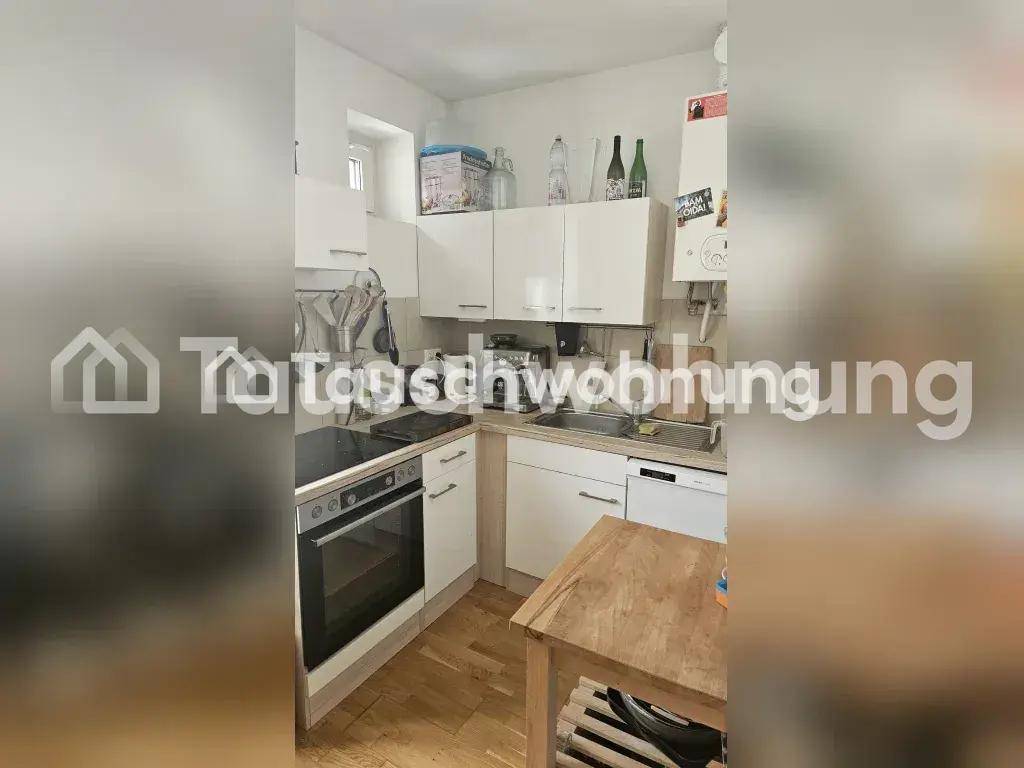 Kleine Küche mit weißen Schränken, Spülmaschine und Holzboden, effizient genutzt.