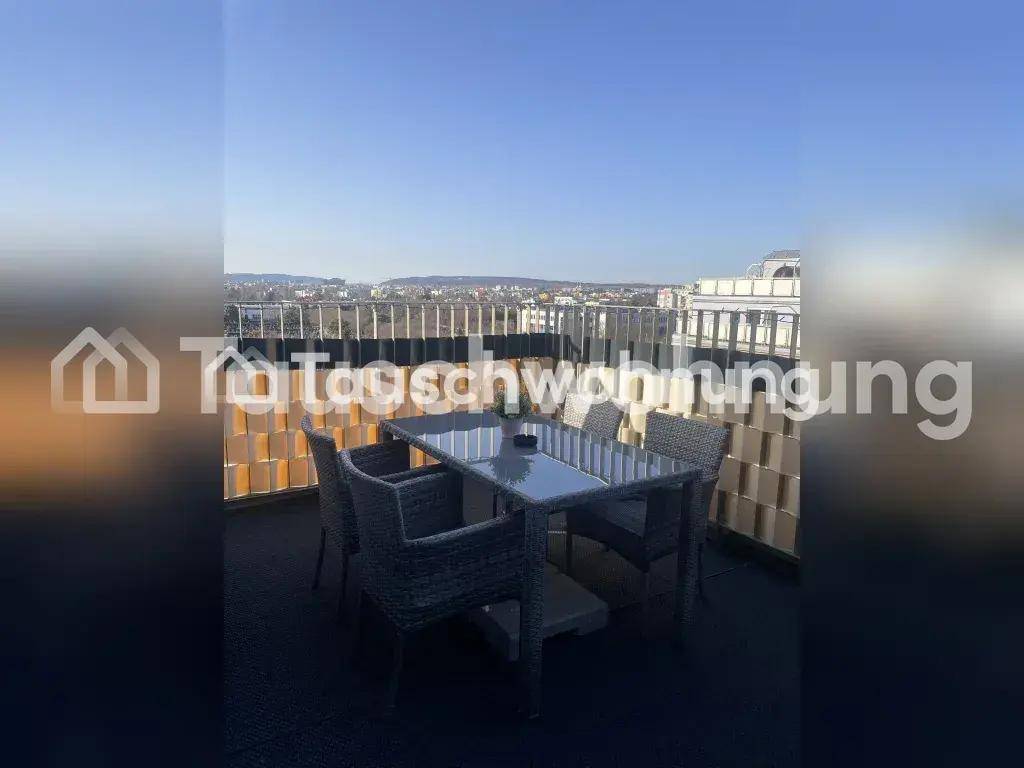 Helle Dachterrasse mit modernen Gartenmöbeln und weitem Blick über die Stadt und Landschaft.