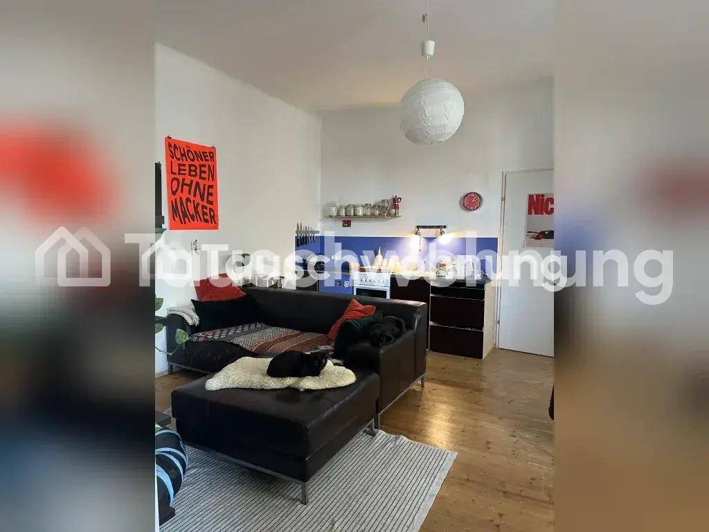Offener Wohnbereich mit Sofa und integrierter kleiner Küchenzeile.