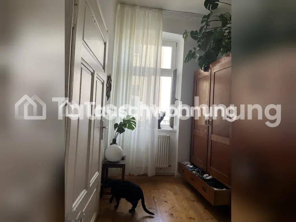 Heller Flur mit Holzboden, Fenster und einem großen Holzschrank.