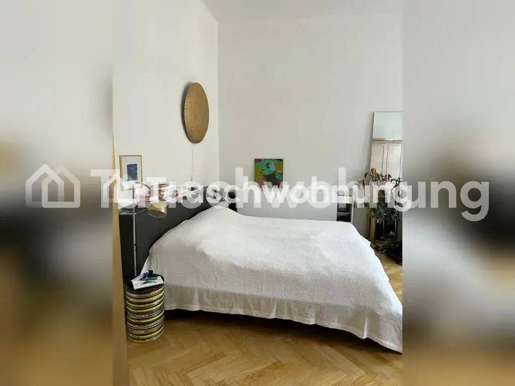 Helles Schlafzimmer mit Fischgrätparkett, einem großen Bett und minimalistischer Dekoration.