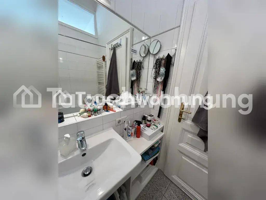 Badezimmer mit Waschbecken, großem Spiegel und weißen Fliesen, mit Handtuchheizkörper.