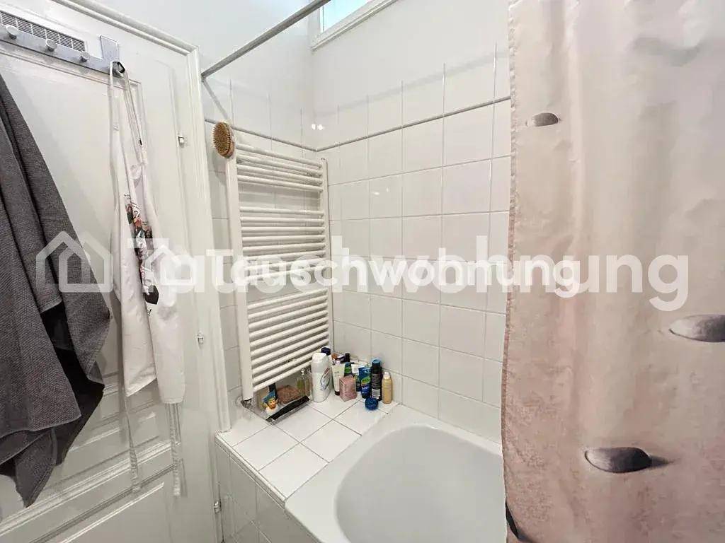 Badezimmer mit Badewanne, Duschvorhang und weißen Fliesen, inklusive Handtuchheizkörper.