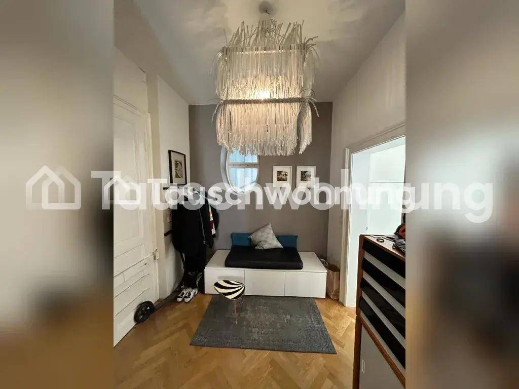 Heller Flur mit Fischgrätparkett, moderner Deckenleuchte und einem kleinen Sitzbereich.