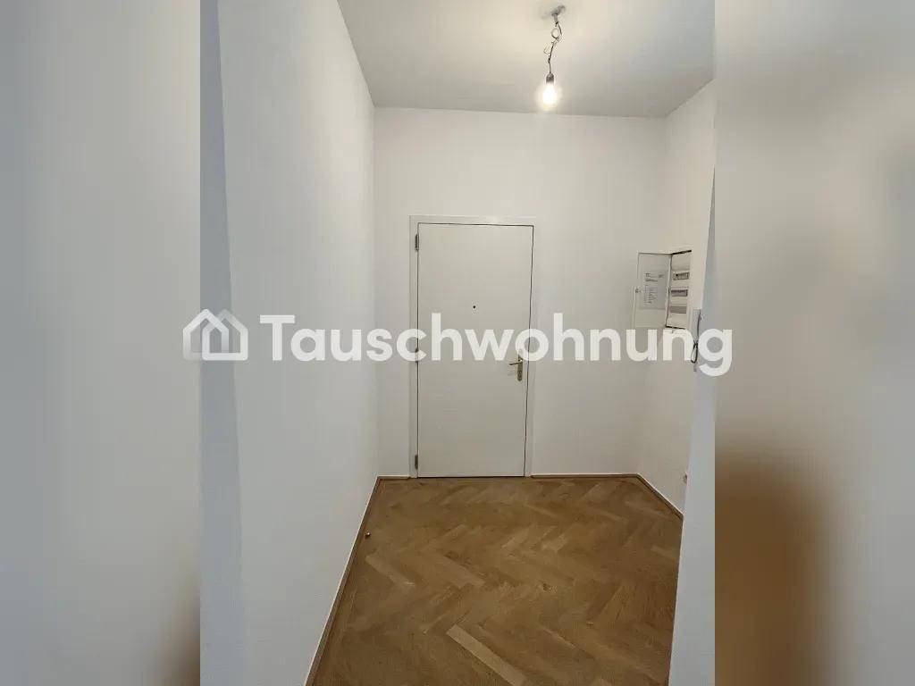 Heller Flur mit Fischgrätparkett und Zugang zur Wohnung, inklusive Sicherungskasten.