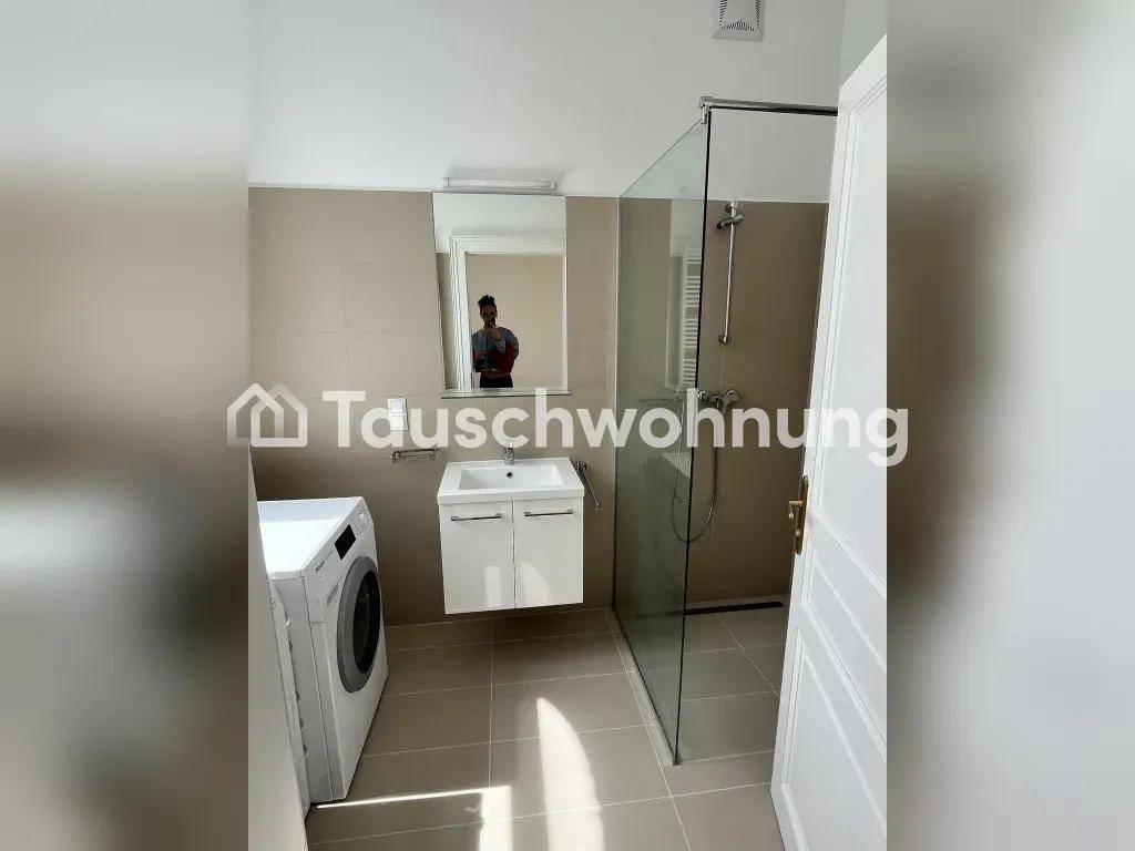Modernes Badezimmer mit begehbarer Dusche, Waschbecken und Waschmaschine.