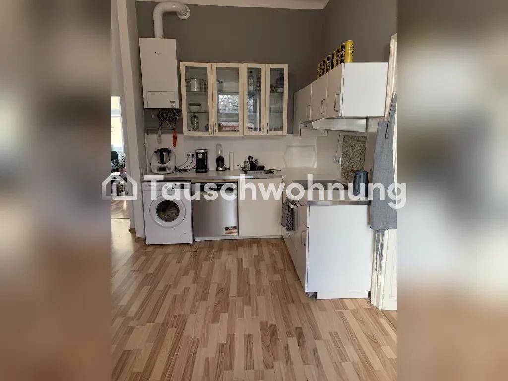 Funktionale Küche mit weißen Schränken, Waschmaschine und Gastherme, praktisch ausgestattet.