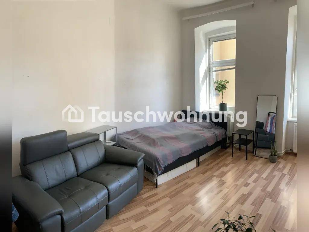 Schlafbereich mit bequemem Bett und Sofa, ergänzt durch einen Spiegel und helle Wände.