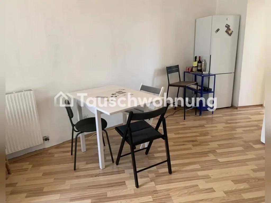 Essbereich mit hellem Laminatboden, Esstisch und Stühlen, ergänzt durch einen Kühlschrank.