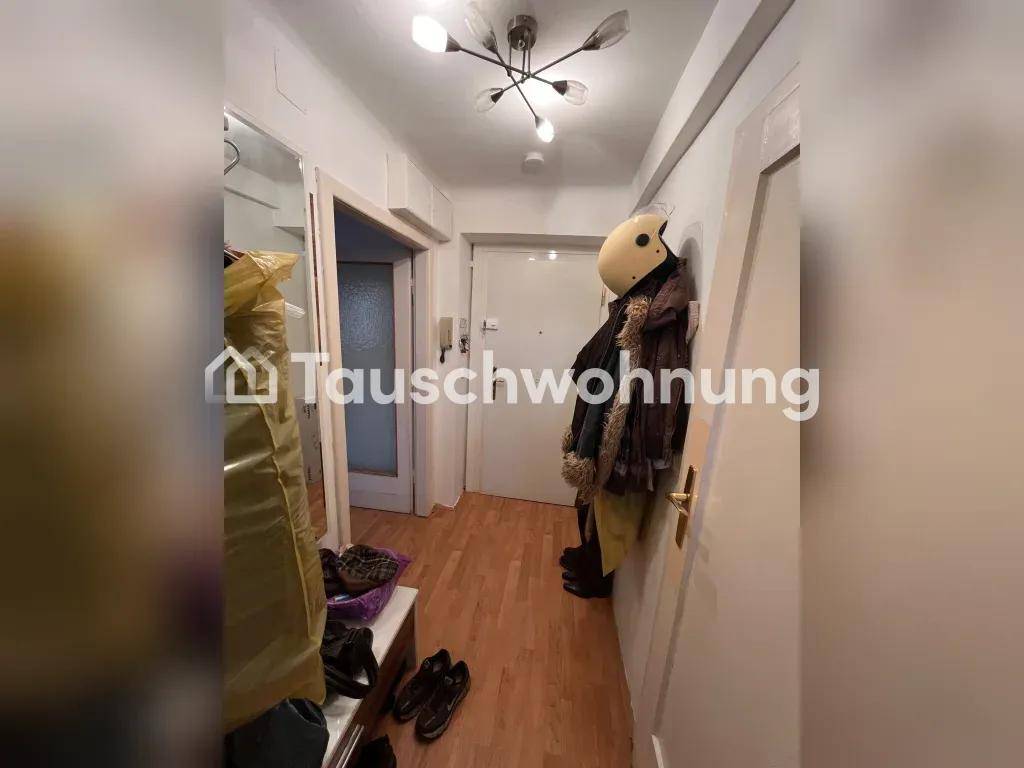 Heller Flur mit Holzboden und Garderobe am Eingangsbereich.