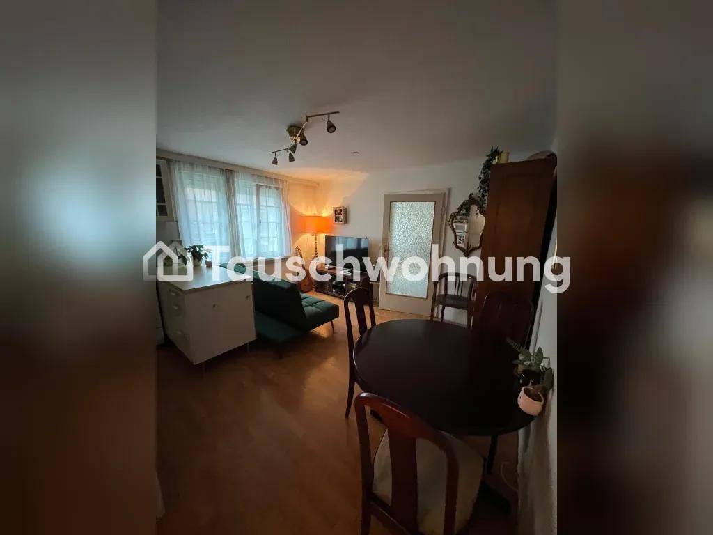 Gemütlicher Wohn-Essbereich mit Holzboden, Esstisch und Sofa.