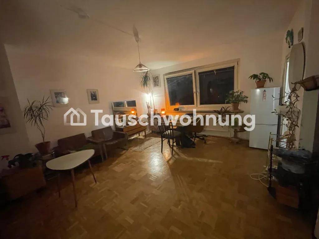 Gemütliches Wohn- und Esszimmer am Abend mit Parkettboden, Vintage-Möbeln und einem Kühlschrank.