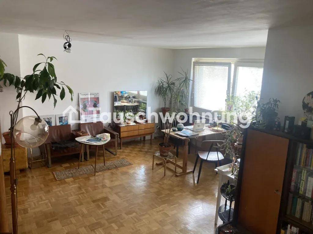 Helles Wohn- und Esszimmer mit Parkettboden, vielen Pflanzen und einem Esstisch am Fenster.