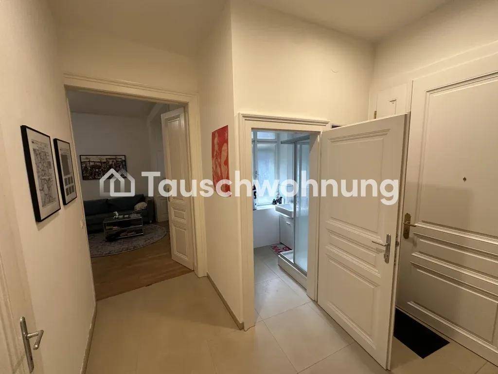 Flur mit Zugang zum Wohnbereich und einem Badezimmer, gekennzeichnet durch weiße Türen.