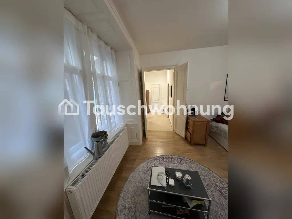 Wohnbereich mit Fenster und Heizkörper, der einen Blick in den angrenzenden Flur bietet.