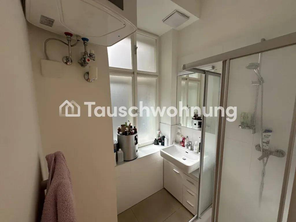Modernes Badezimmer mit Duschkabine, Waschbecken und Fenster für natürliche Belüftung.