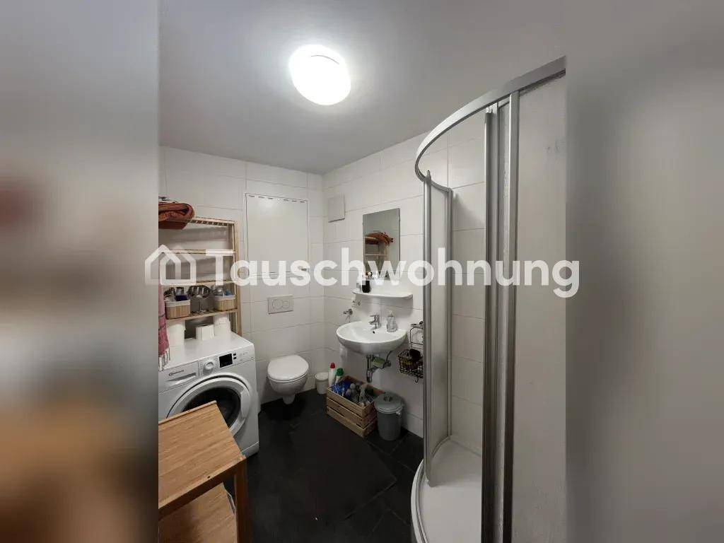 Funktionales Badezimmer mit Duschkabine, WC, Waschbecken und einer Waschmaschine.