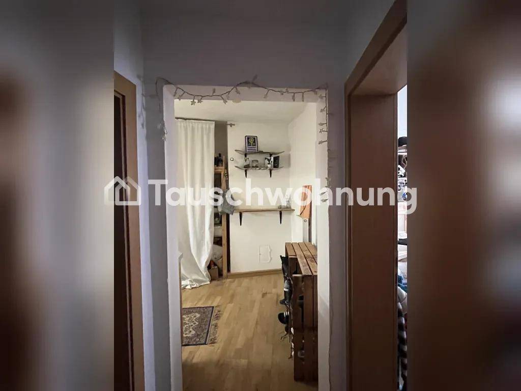Schmaler Durchgangsbereich mit Holzboden und einer Lichterkette über dem Türrahmen.