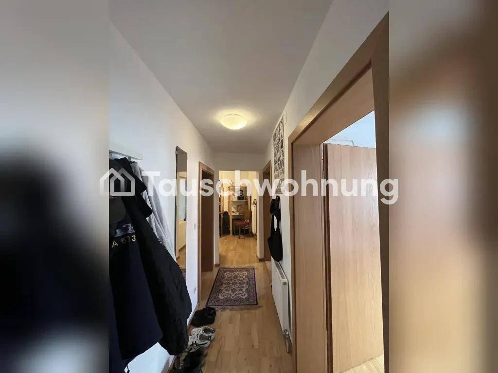 Langer Flur mit Holzboden, Garderobe und einem Teppich, der zu weiteren Räumen führt.