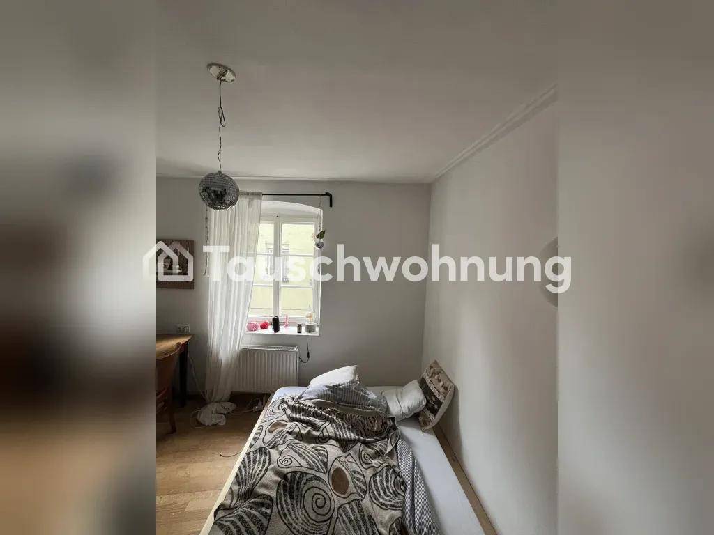 Gemütliches Schlafzimmer mit Einzelbett, kleinem Fenster und einer Discokugel-Lampe an der Decke.