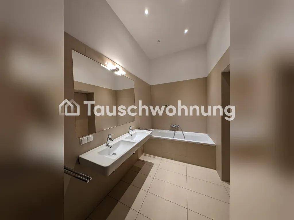 Modernes Badezimmer mit Doppelwaschbecken, Badewanne und beigefarbenen Fliesen an Wänden und Boden.