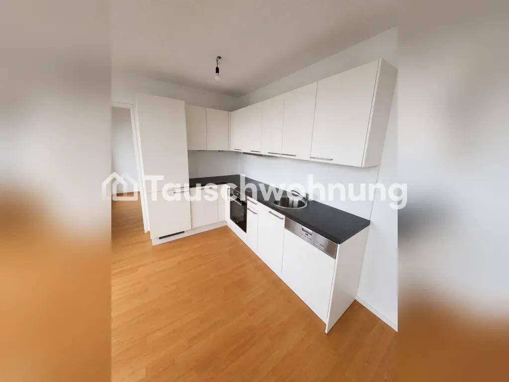 Moderne Küchenzeile mit weißen Schränken, dunkler Arbeitsplatte und integriertem Geschirrspüler.